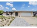 Charming single-story home with a well-maintained lawn, arched entryway, and an attached two-car garage at 9115 Panda Ln, Port Richey, FL 34668
