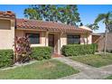 Inviting front exterior of a home featuring a well-maintained yard and a charming tile roof at 9737 86Th Ave, Seminole, FL 33777