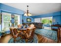 Bright living room with blue walls and decor, a dining table, and a comfortable gray sectional sofa at 9945 47Th N Ave # 210, St Petersburg, FL 33708