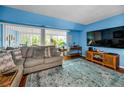 A well-lit living room with stylish furnishings, blue walls, hardwood floors, and an area rug at 9945 47Th N Ave # 210, St Petersburg, FL 33708