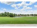Scenic view of the lush green golf course with a serene lake under a bright, cloudy sky at 10232 Buncombe Way, San Antonio, FL 33576
