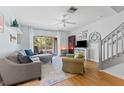 Inviting living room with wood floors, ceiling fan, comfortable seating and sliding glass door to the backyard at 1044 Kennewick Ct, Wesley Chapel, FL 33543