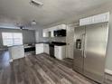 Bright kitchen featuring stainless steel appliances, granite countertops, and new wood-look vinyl flooring at 1215 Windsor Cir, Brandon, FL 33510