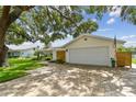 A single-Gathering home with a two car garage, brick pavers, and an American flag displayed at 1286 Stony Brook Ln, Dunedin, FL 34698
