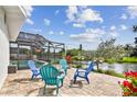 An outdoor patio space with furniture overlooking a pond in a fenced backyard at 1286 Stony Brook Ln, Dunedin, FL 34698