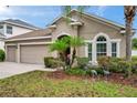 A lovely yard features lush landscaping and decorative crane ornaments at 1328 Rushgrove Cir, Dover, FL 33527