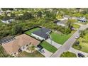 Aerial view of the property showing the modern home, black fence, driveway, and neighboring houses at 14009 Wenzel Ave, Port Charlotte, FL 33981