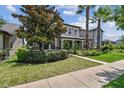 Inviting two-story home with lush landscaping, mature trees, and a welcoming front lawn at 14110 Barrington Stowers Dr, Lithia, FL 33547