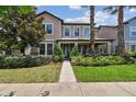 Charming two-story home with a well-kept lawn, neatly trimmed bushes, and a stone-accented facade at 14110 Barrington Stowers Dr, Lithia, FL 33547