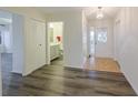 Bright hallway featuring hardwood floors, white doors, and access to bathroom at 1508 Ingram Dr # 20, Sun City Center, FL 33573