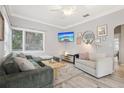 Cozy living room with sectional sofa, whitewashed floors, and a large window for natural light at 1525 38Th N Ave, St Petersburg, FL 33704