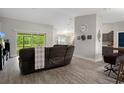 Bright and airy living room with a sliding glass door and view into the kitchen area at 16473 Scaup Duck Ave, Weeki Wachee, FL 34614