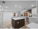 Spacious kitchen featuring a large island, white cabinets, stainless appliances, and travertine floors at 1721 Allens Creek Dr, Clearwater, FL 33764