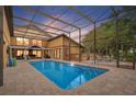 Sparkling pool surrounded by a screened enclosure and brick pavers, creating an ideal outdoor oasis at 1721 Allens Creek Dr, Clearwater, FL 33764