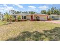 Inviting single-story home with a lush front lawn and vibrant landscaping, perfect for curb appeal at 1839 Neptune Dr, Englewood, FL 34223