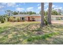 Cozy single-story house with a well-kept lawn, framed by mature trees, offering a serene suburban setting at 1839 Neptune Dr, Englewood, FL 34223