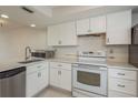 Updated kitchen with white cabinets, modern countertops, stainless steel dishwasher, and a microwave at 210 Martha Ln # 210, Oldsmar, FL 34677