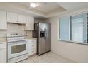 Compact kitchen featuring white cabinets, stainless steel appliances, and a window bringing in natural light at 210 Martha Ln # 210, Oldsmar, FL 34677