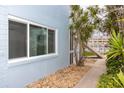 Side view of the building near a sidewalk leading to a waterway with nearby boats, enhanced by beautiful landscaping at 241 Skiff Pt # 1, Clearwater Beach, FL 33767