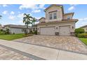 Charming two-story home featuring a three-car garage, paver driveway, and professionally landscaped front yard at 2724 Coco Palm Cir, Wesley Chapel, FL 33543