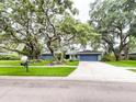 Quaint single-story home with a well-kept lawn, mature trees, and a two-car garage, offering curb appeal at 3005 Wilton Ln, Valrico, FL 33596