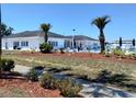 Community clubhouse with a pool surrounded by mulch, shrubbery, and palm trees at 35152 Dodie, Zephyrhills, FL 33541
