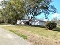 Charming home with mature trees, flowering bushes, and a two-car garage at 39343/39349 Rusbe, Zephyrhills, FL 33540