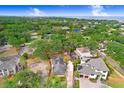 Aerial view of a property with a fenced boundary surrounded by trees, near the water at 4640 W Lamb Ave, Tampa, FL 33629