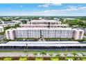 Aerial view of a condominium building with a parking area surrounded by lush landscaping at 5501 80Th N St # 206, St Petersburg, FL 33709