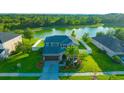 Aerial view of a beautiful two-story home overlooking a peaceful pond and lush greenery in the backyard at 5624 Fisher Glen Loop, Wesley Chapel, FL 33545
