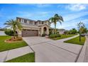 Charming two-story home featuring a well-manicured lawn, a two car garage, and a cozy front porch at 5624 Fisher Glen Loop, Wesley Chapel, FL 33545