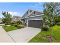 Charming home with blue siding, a well-manicured lawn, and a concrete driveway at 5742 Stockport St, Riverview, FL 33578