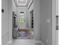 Bright entryway with neutral walls, a decorative rug, and a coat rack with bench at 5742 Stockport St, Riverview, FL 33578