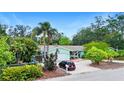 Charming single-story home with a one-car garage, surrounded by mature trees and tropical plants at 6011 Tangerine S Ave, Gulfport, FL 33707