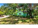 Landscaped front yard with mature trees and greenery surrounds the lovely single-story home at 6011 Tangerine S Ave, Gulfport, FL 33707