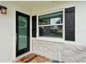 Welcoming front door with black frame, stone facade, and a cheerful welcome mat at 6913 Grande Vista S Way, St Petersburg, FL 33707