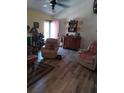 Cozy living room with vaulted ceilings, luxury vinyl flooring, a ceiling fan, and lots of natural light at 7608 Chenkin, Zephyrhills, FL 33540