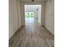 Hallway with gray wood-grain tile leading to the living area and views of the backyard at 8316 Golden Beach Ct, Parrish, FL 34219