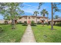 Charming two-story townhome showcasing landscaped front yard, manicured hedges, and a tile roof at 9521 86Th Ave # 9521, Seminole, FL 33777
