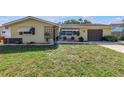 Inviting single-story home with a well-maintained lawn, tidy flower beds, and a cozy seating area at 9892 111Th St, Seminole, FL 33772