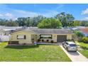 A well-maintained single Gathering home with a manicured lawn, flowerbeds, and a cozy seating area at 9892 111Th St, Seminole, FL 33772