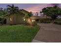 Well-maintained home with a lush green lawn, palm trees, and a spacious driveway creates inviting curb appeal at 115 Lake Shore E Dr, Palm Harbor, FL 34684