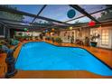 Relaxing enclosed pool area featuring vibrant lanterns and lush plants, perfect for outdoor enjoyment at 1151 Lancer Ln, Tarpon Springs, FL 34689