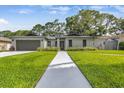 Well-maintained single-story home with manicured lawn and walkway leading to the front door at 12807 Starling Dr, Odessa, FL 33556