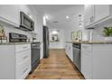 Modern kitchen with stainless steel appliances, white cabinets, and wood floors at 12807 Starling Dr, Odessa, FL 33556