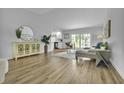 Bright living room with wood floors, neutral paint, and natural light, next to the open kitchen at 12807 Starling Dr, Odessa, FL 33556