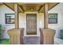 A welcoming front porch with dark wood columns, a neutral door, and symmetrical windows at 1400 Tarpon Woods Blvd # A4, Palm Harbor, FL 34685