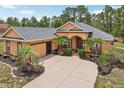 Inviting single-story home with a well-manicured front yard, mature palms, attached garage and decorative landscaping at 14494 Copeland Way, Brooksville, FL 34604