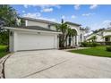 Desirable two-story home featuring a manicured lawn, a two-car garage, and lush tropical landscaping at 16003 Ridley Pl, Tampa, FL 33647