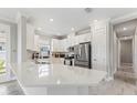 Bright kitchen with white cabinets, stainless steel appliances, quartz countertops and gray tiled flooring at 16126 San Donato Pl, Bradenton, FL 34211